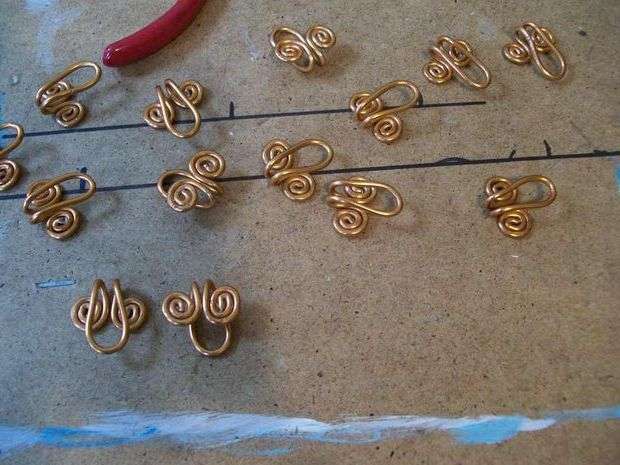 ابدأ في تحريف اللولب على كلا الجانبين. قم بإعداد مثل هذه الفراغات مسبقًا ، ثم ثنيها إلى النصف. سيكون لديك خطافات ستبقى متصلة ببعضها البعض.