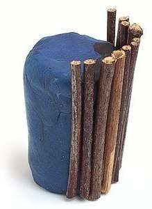 Nu kan du begynde at lave gryden. For at gøre dette skal du bruge et stort stykke plasticine, hvorfra du skal rulle en cylinder. Brug lige pinde til at dekorere gryden. Du kan endda bruge træspyd, hvis du ikke har fundet nok tørre kviste uden bøjninger.