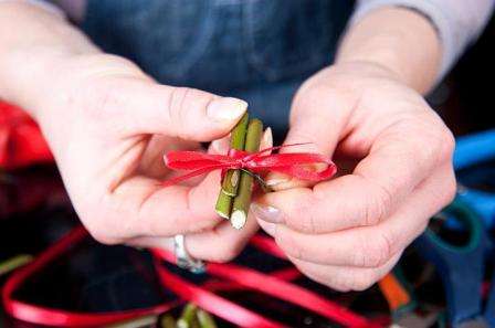 For at give spisepindene et pænt udseende, brug tape til at dække tråden. Skær enden af ​​tråden lidt og stik derefter pindene i oasen oven på bladene.