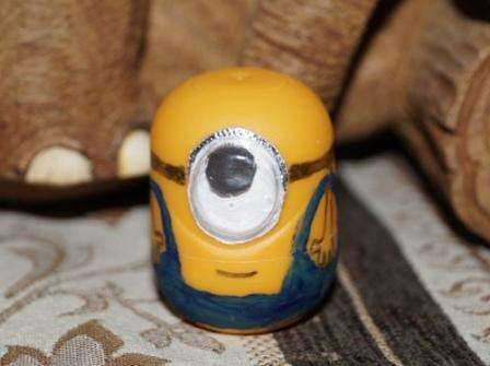 Liimaa silmä ylhäällä olevaan ystävällisempään. Sitten sinä tai lapsesi voitte alkaa värjätä askartelua. Ota esimerkkinä kuva sarjakuvan minionista ja yritä maalata hänen vaatteensa guassi- tai akryylimaaleilla.