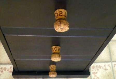 Merkitse ensin lyijykynällä korkin kapean puolen keskikohta. Työnnä ruuvia oven tai vetolaatikon takaa kärjellä eteenpäin ja pidä sitä tukevasti ruuvitaltalla.