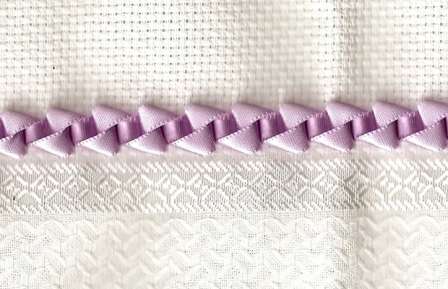 Start med hovedsømmen ved at trække tapen gennem hakene. Træk derefter tapen gennem sømmen for et flot kantmønster.